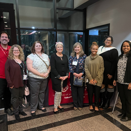 Bob Serianni and Radhika Aravamudhan standing for a photo with the CSD advisors in the lobby 