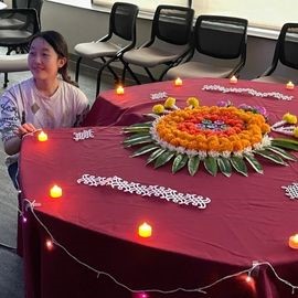 Student next to Diwali table decoration