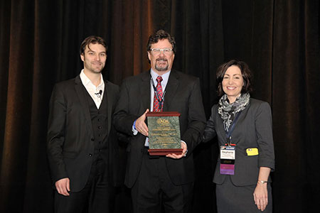 dr. bray, center, holding award