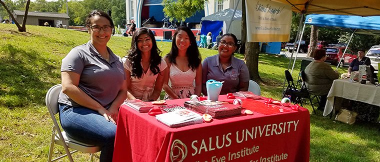 Salus University representatives hosting a table at an event