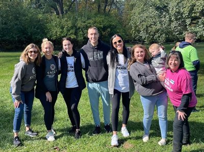 Students/staff/faculty who participated in the Walk For Apraxia standing together outside smiling for a photo