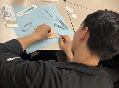 TEI resident practicing surgical sutures