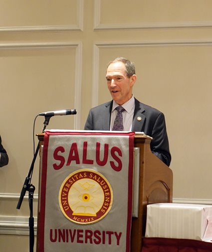 Dr. Mittelman speaking at a podium