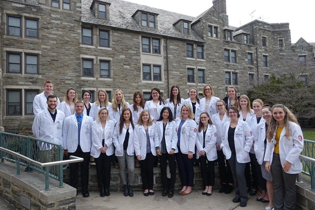 PA students in their white coats outside of Inglis House