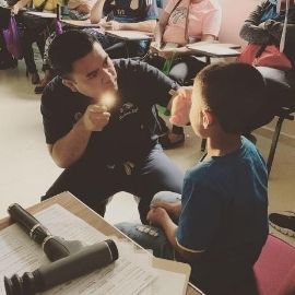 Dr. Higa providing an eye exam to a pediatric patient