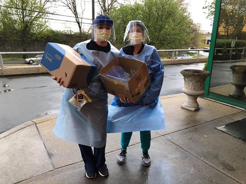 Volunteers holding mask donation boxes