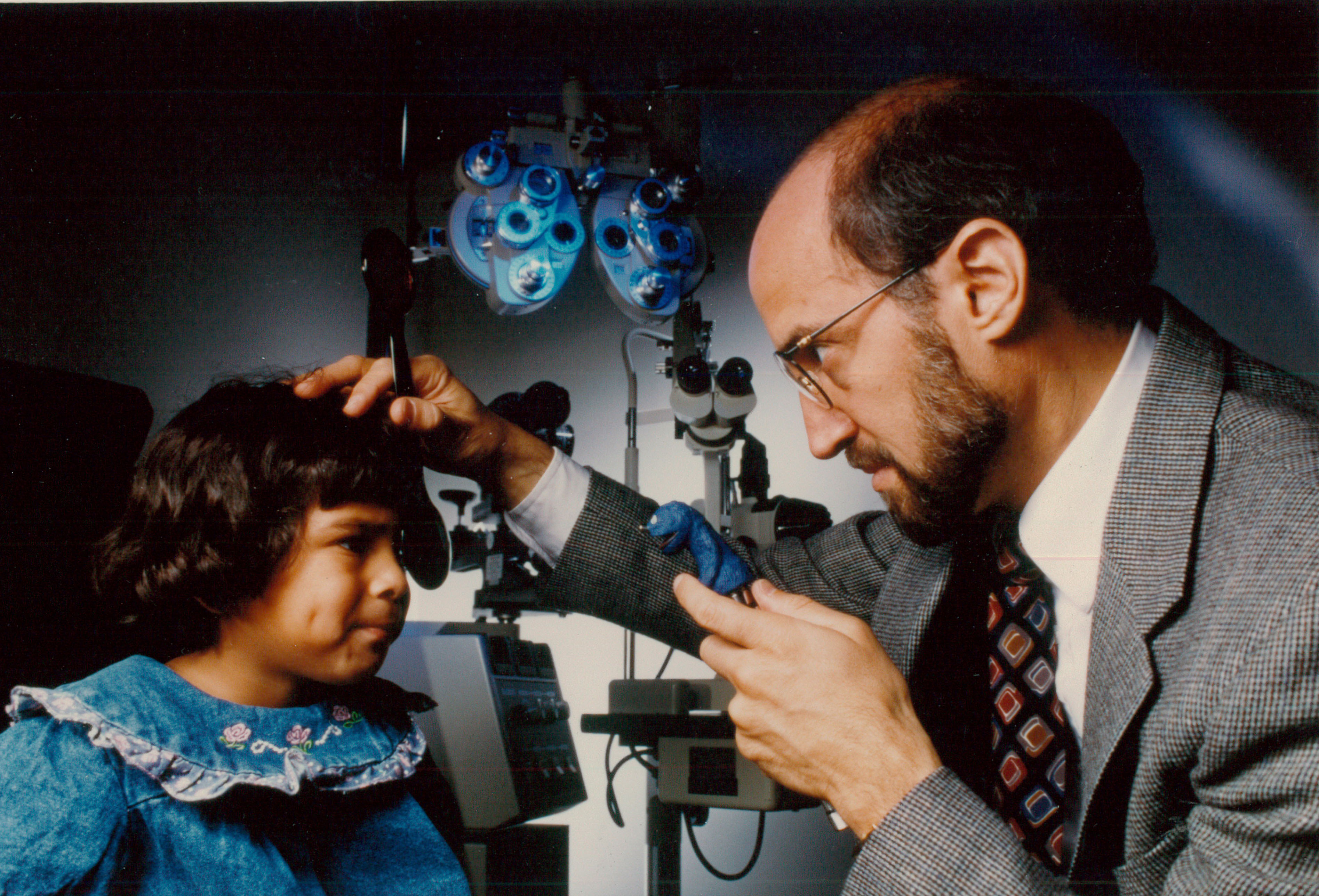 Mitchell Scheiman providing an eye exam to a pediatric patient