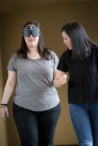 Student guiding a person with an eye covering