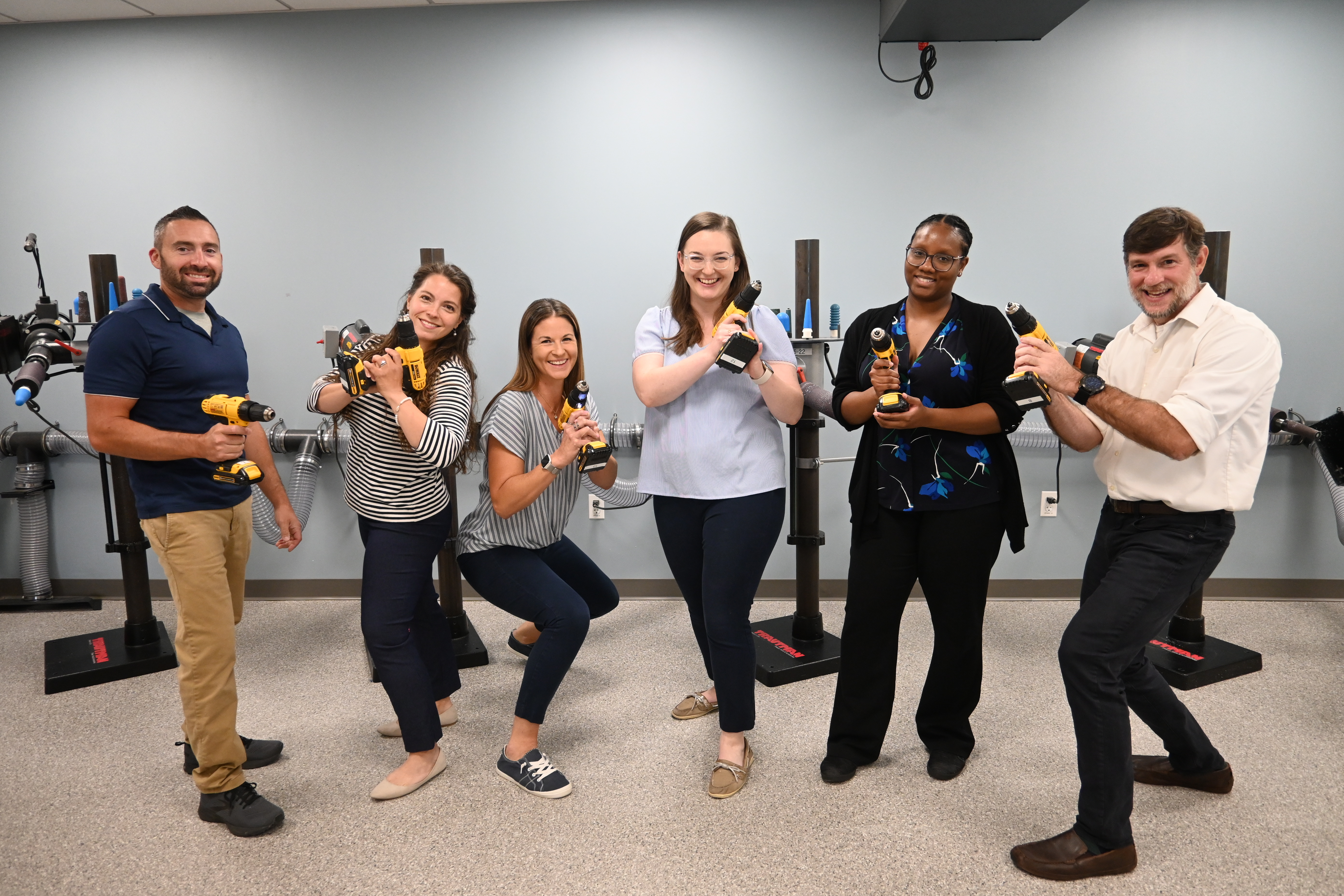 O&P faculty posing for a group photo holding drills