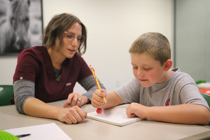 OT professional helping child with handwriting