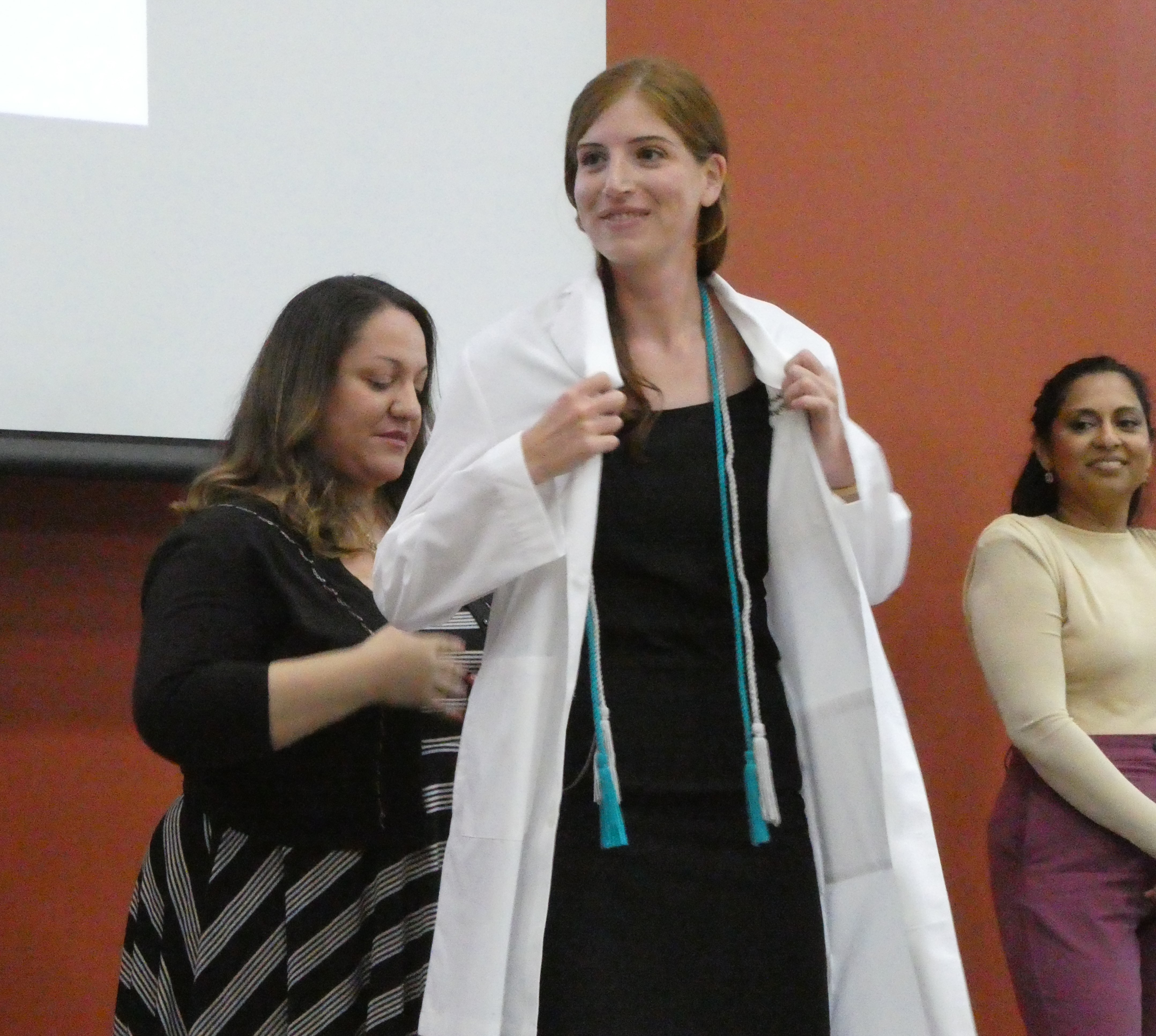 Morgan Gianelle putting on long white coat