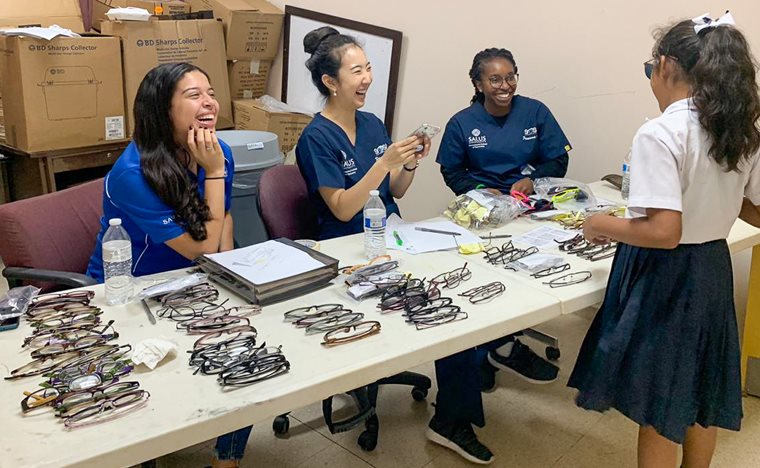 Optometry students talking with a child in Panama