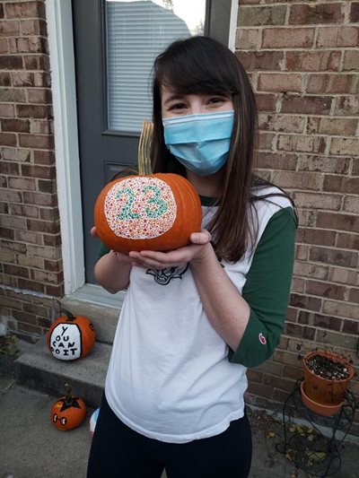 Student holding a pumpkin