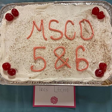 Photo of tres leche cake decorated with the words MSCO 5 and 6