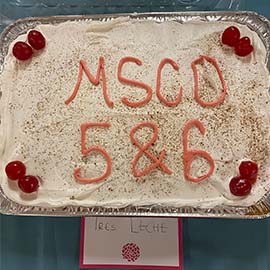 Photo of tres leche cake decorated with the words MSCO 5 and 6