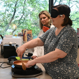 Student using a pan with a blindfold