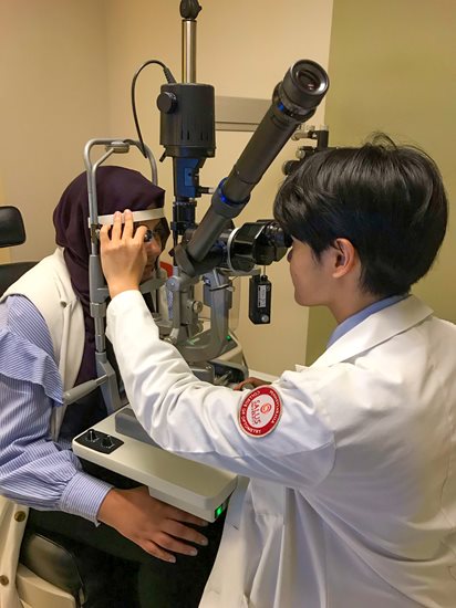 Ryan Yee giving a patient an eye exam