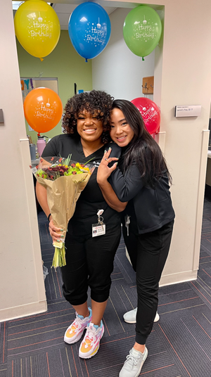 2 Residents hugging with balloons and flowers