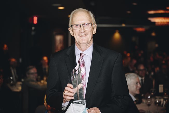 Dr. Thomas Lewis holding an award