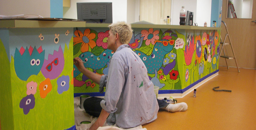 Person painting the TEI mural