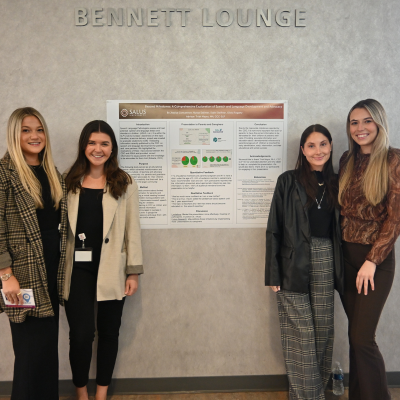 Jessica Concannon, Alyssa Dallmer, Sydni Delfiner, and Olivia Fogarty standing in front of their capstone poster