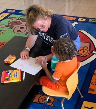 Student works with child on mission trip