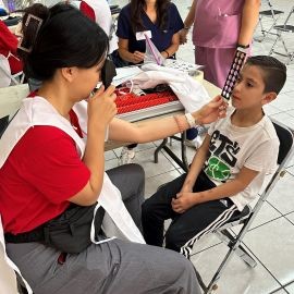 SOSH student providing an eye exam