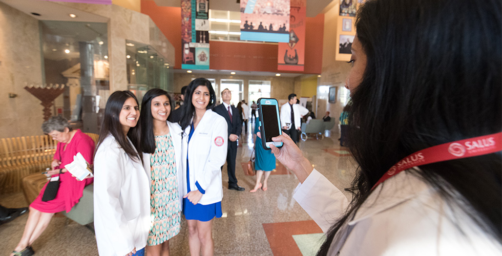 students in white coats getting their photo taken