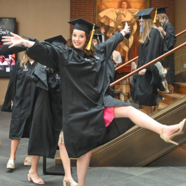 Graduate posing before walking into auditorium