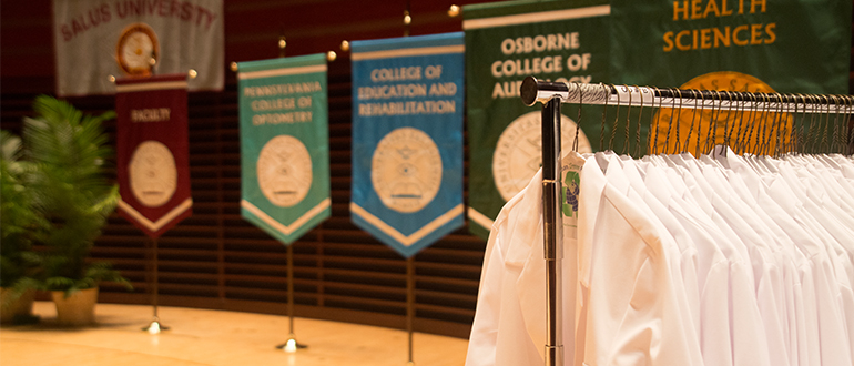 white coats on a clothing rack