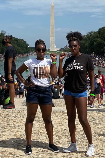 Two student leaders of the Black Student Union (BSU) being photographed in front of the Washington Monument in Washington, D.C.