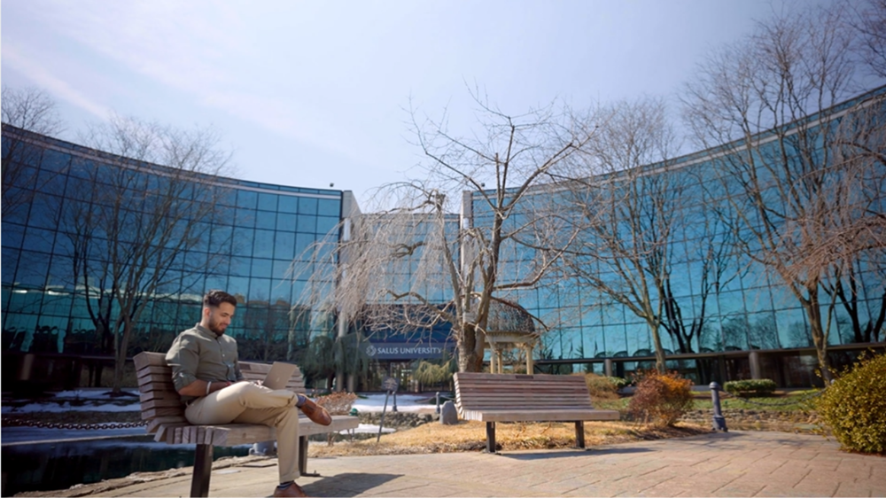 Dr. Mohit Batra on a bench outside of Salus