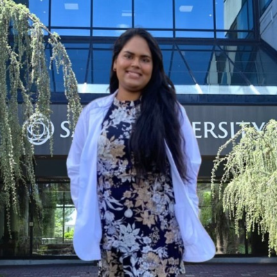 Afrida in her white coat in front of Salus