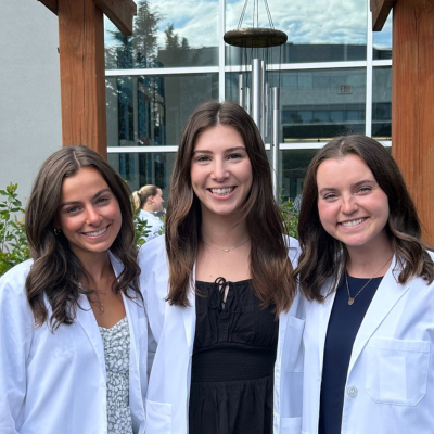 three OT students in their white coats